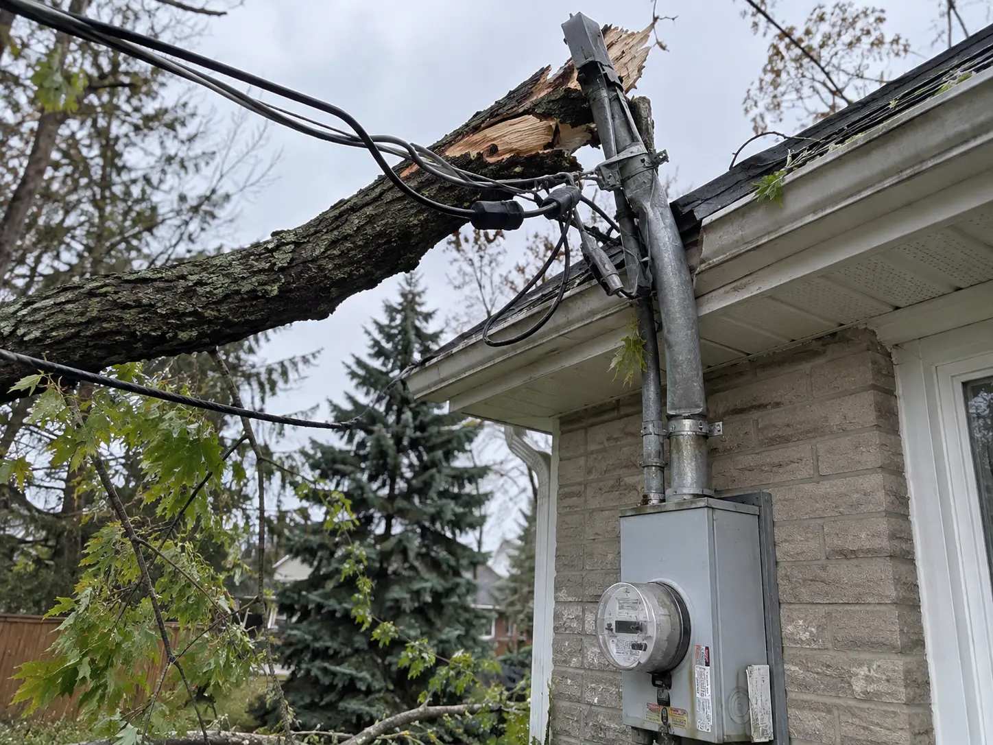 Emergency electrician Aurora inspecting storm damage to a residential service mast